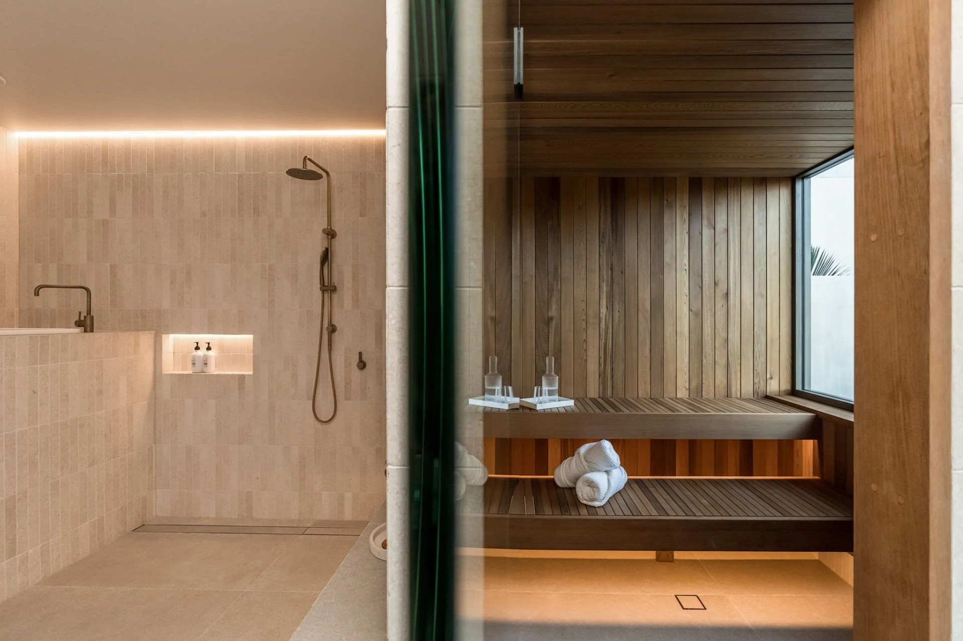 Warm-lit ensuite with rainfall shower and adjoining timber-lined sauna, hot water delivered with pressure and consistency
