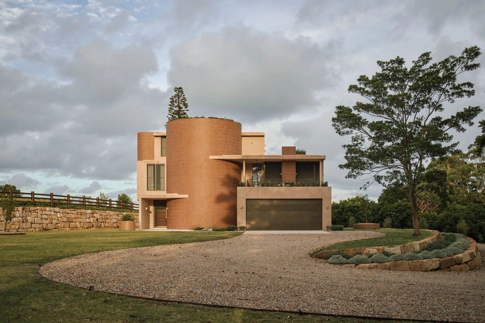 Completed architect-designed coastal home in Byron Bay at warm dusk, white render, timber cladding and native planting